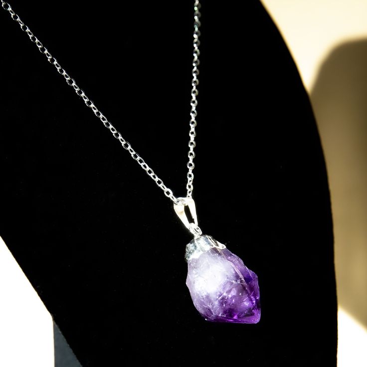 "Purple Amethyst is a very powerful stone, stimulating and soothing the mind and emotions. Keep it close to you to provide protection and strength. The stone has been kept in its most organic form possible. Mounted by hand onto an 18\" silver chain." Spiritual Amethyst Crystal Necklace With Raw Stone, Spiritual Amethyst Crystal For Gift, Spiritual Mineral Crystal Necklace With Large Stone, Spiritual Crystal Necklace With Large Stone, Spiritual Purple Crystal Necklace With Raw Stone, Spiritual Large Stone Mineral Crystal Necklace, Spiritual Amethyst Crystal Gemstone Necklace, Amethyst Crystals For Healing, Spiritual Amethyst Crystals