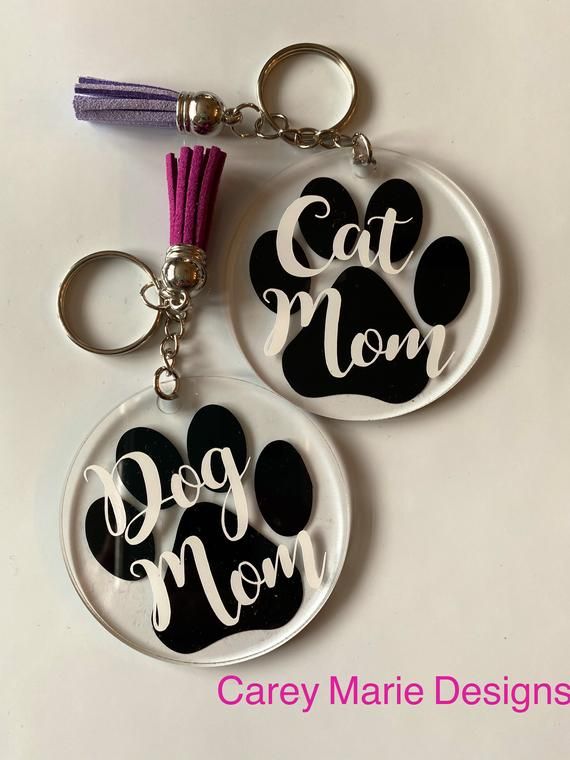 two key chains with the words cat mom and dog mom written on them are shown