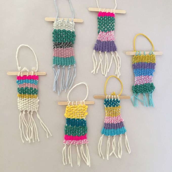 four different colored macrame hangings on a wall