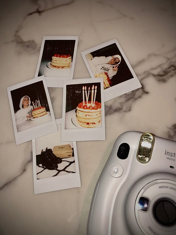 polaroid camera sitting on top of a table next to four pictures with candles in them