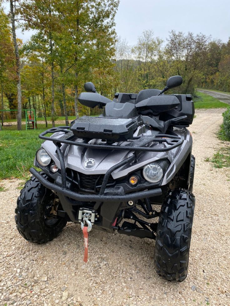 a four - wheeler is parked on the side of a dirt road