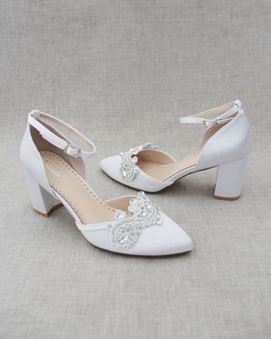 two pairs of white shoes with bows on the toes and heels are sitting next to each other