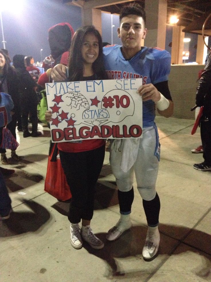 a man and woman standing next to each other holding a sign