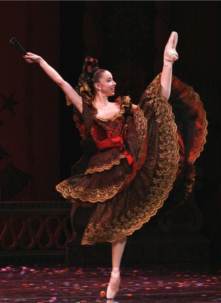 the ballerina is dressed in an elaborate dress and holding her arms out to the side