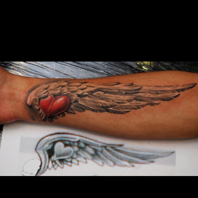 an arm with wings and a heart on it