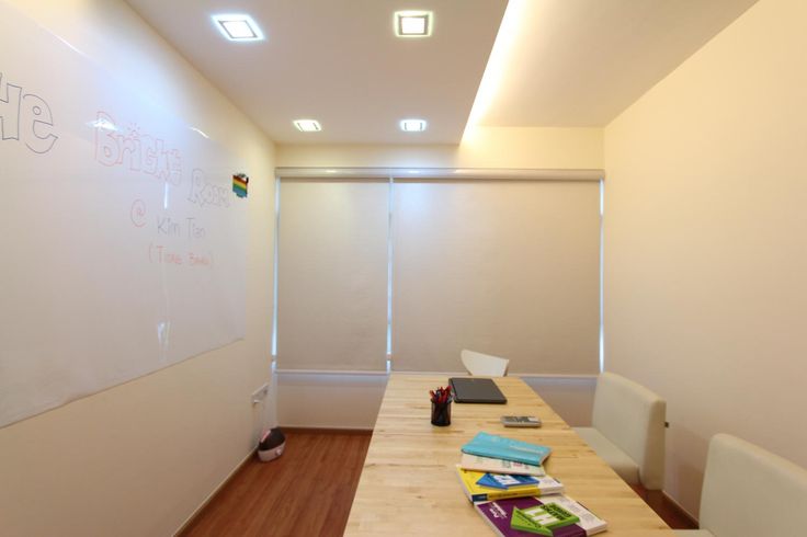 a long table with some books on top of it in front of a whiteboard