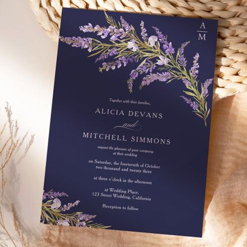 a wedding card with purple flowers on it next to a wicker basket full of lavenders