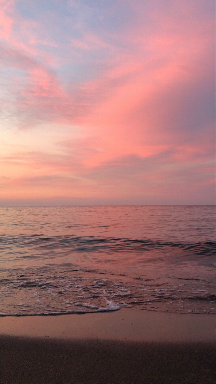 the sky is pink and purple over the ocean