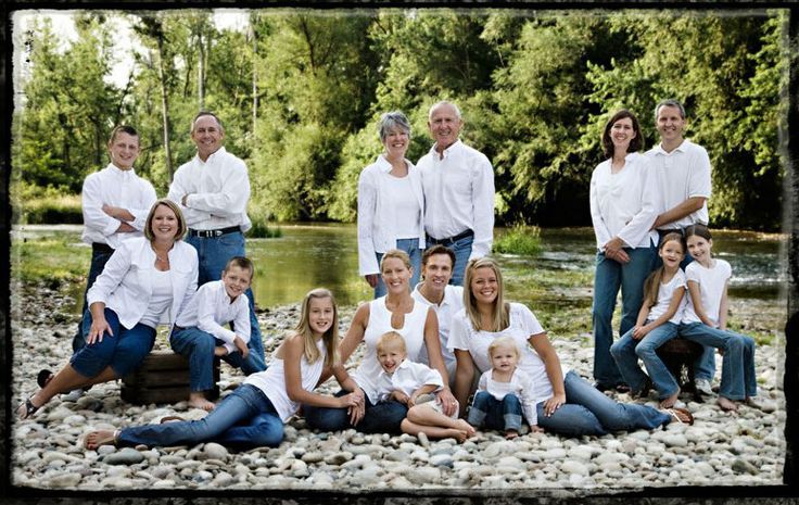 a large group of people posing for a photo in front of a body of water