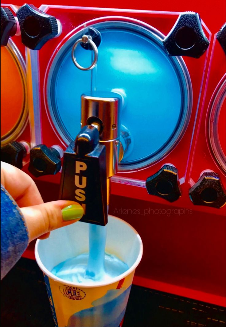 a person is holding a cup in front of a machine