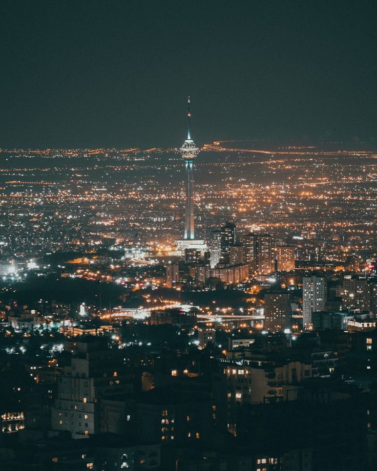 the city lights shine brightly at night in this view from top of a skyscraper building