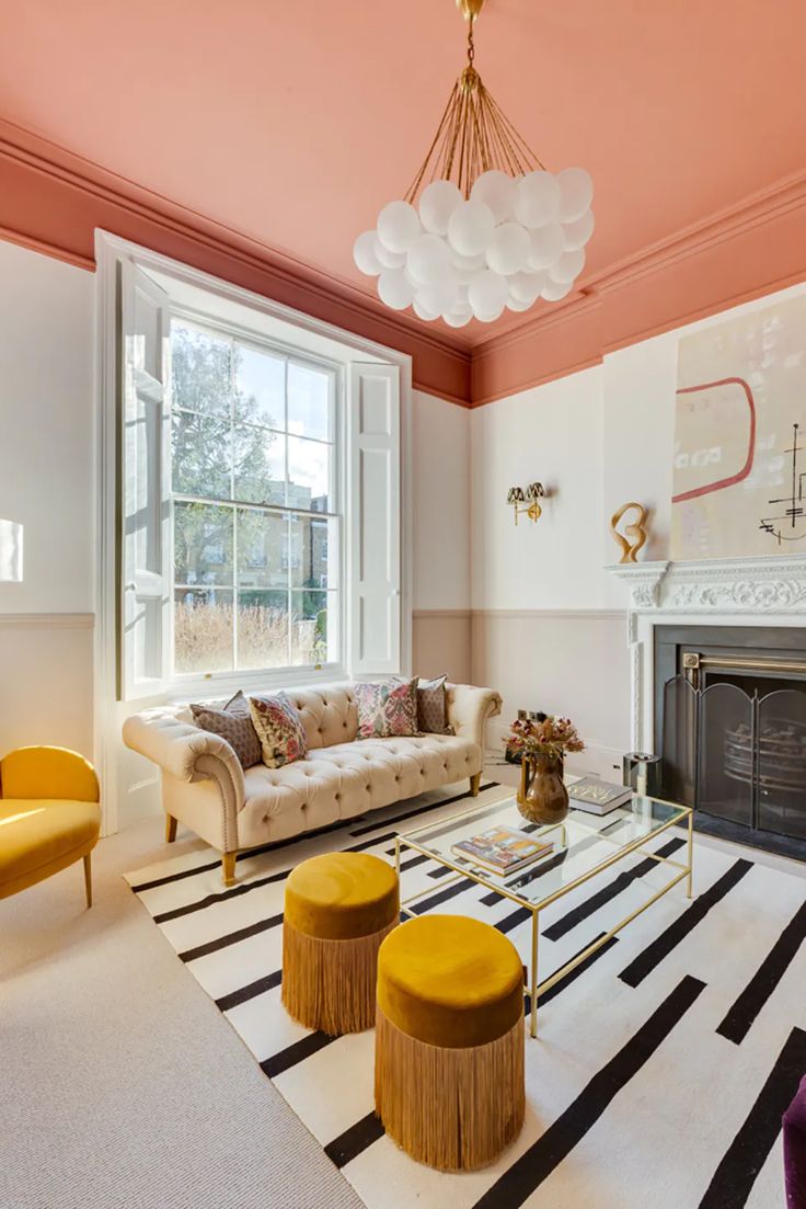 a living room with pink walls and white furniture