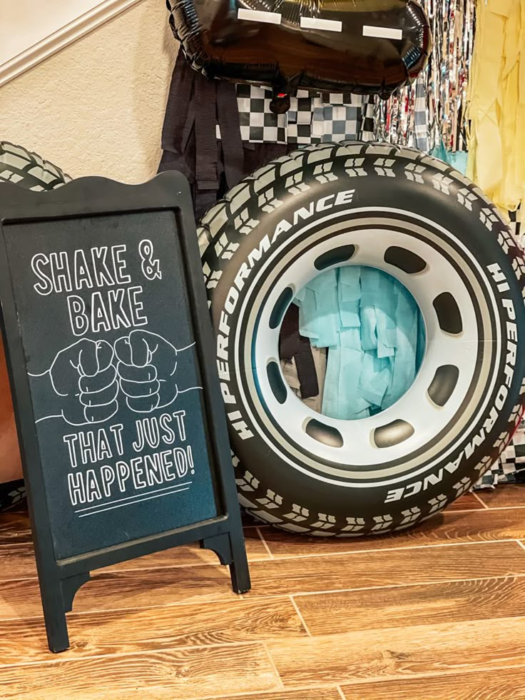 there is a chalkboard sign next to a tire and some other items on the floor