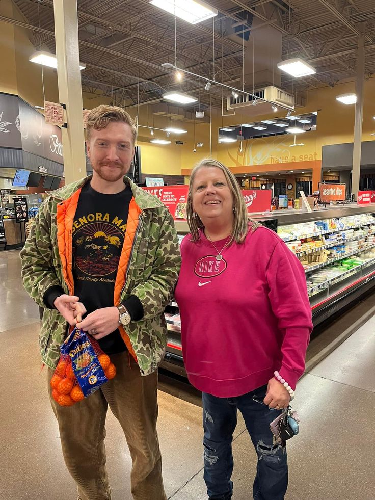 a man and woman standing next to each other in a grocery store