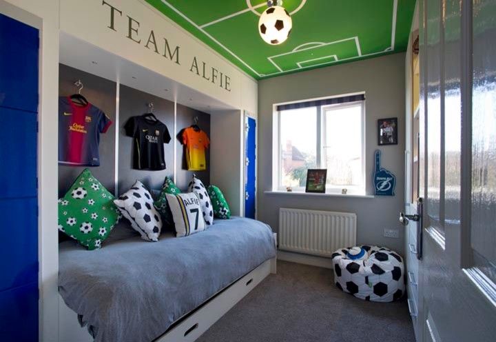 a bedroom with a soccer theme painted on the ceiling and bed in the corner,