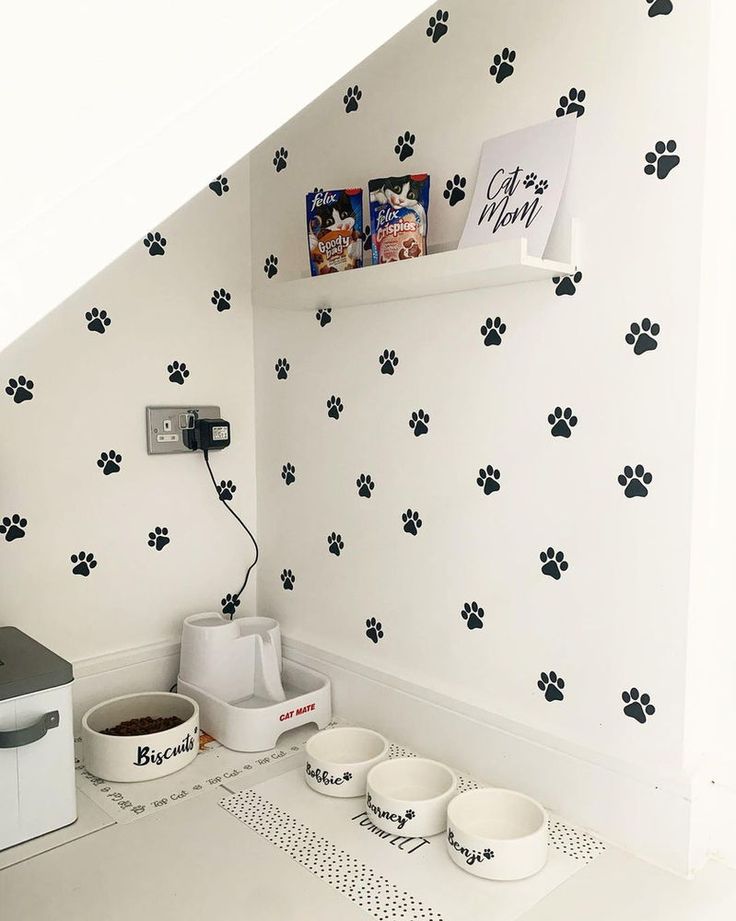 a dog's paw prints are on the wall next to bowls and a microwave