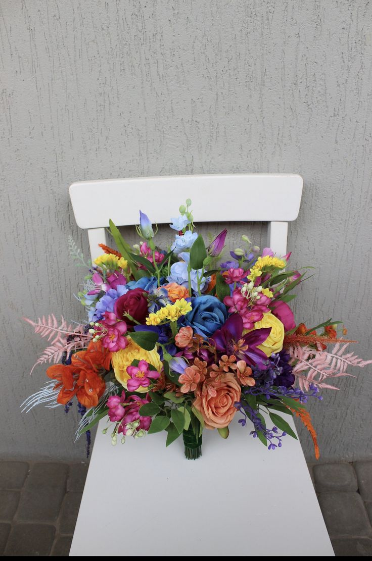 a bouquet of flowers sitting on top of a white chair