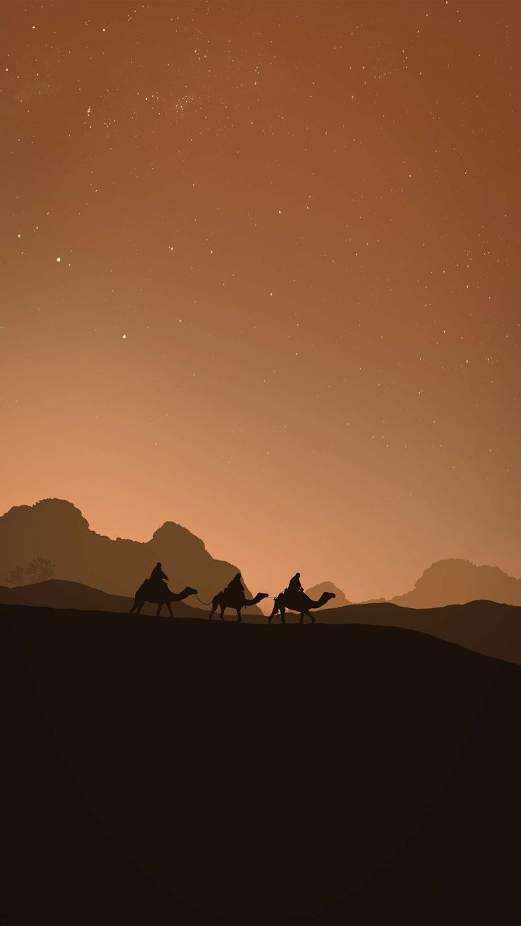 three people riding camels across a desert under a night sky with mountains in the background