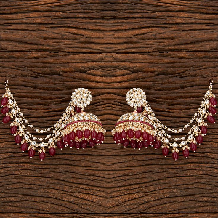 Add a regal look to your outfits with our Rani Pankhuri Earrings. These Gold-Plated beauties feature Kundan with Rani beads and a stunning Kaan chain design. Specifications Materials used: Kundan, Rani beads Length: 7.5 cm, Width: 6 cm Weight: 8.1 grams At Romikas, we pride ourselves on the craftsmanship and high quality of our jewelry, designed to enhance your natural beauty. Please contact us with any questions. Chandbali Temple Jewelry Earrings With Latkans, Red Jhumkas With Latkans For Puja, Temple Jewelry Chandbali Earrings With Latkans, Temple Jewelry Meenakari Drop Jhumkas, Temple Jewelry Kundan Jhumkas With Matching Earrings, Festive Traditional Meenakari Chandelier Earrings, Traditional Meenakari Chandelier Earrings For Festive Occasions, Red Latkans Jhumkas For Puja, Traditional Heavy Earrings For Puja