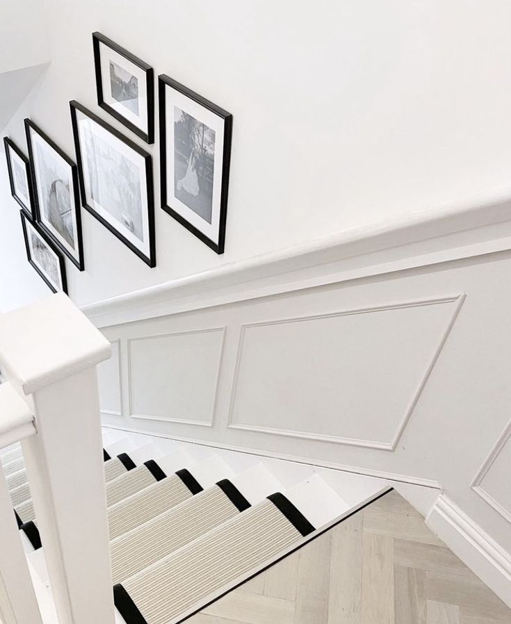 the stairs are lined with black and white pictures