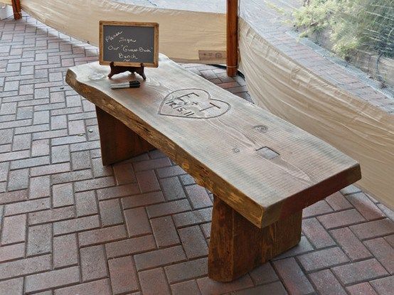 a wooden bench sitting on top of a brick floor next to a sign that says welcome