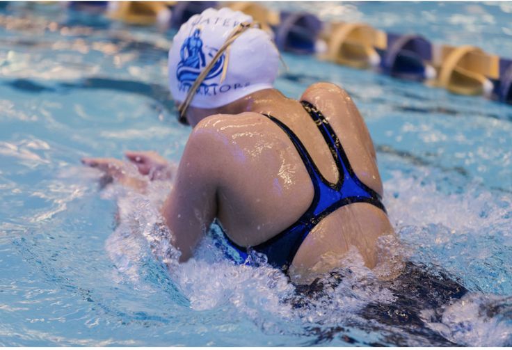 a woman swimming in a pool wearing a swim cap