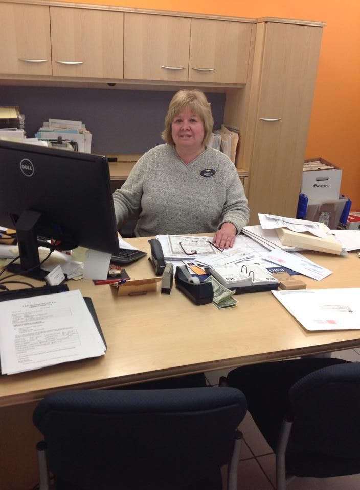 a woman sitting at a desk in front of a computer