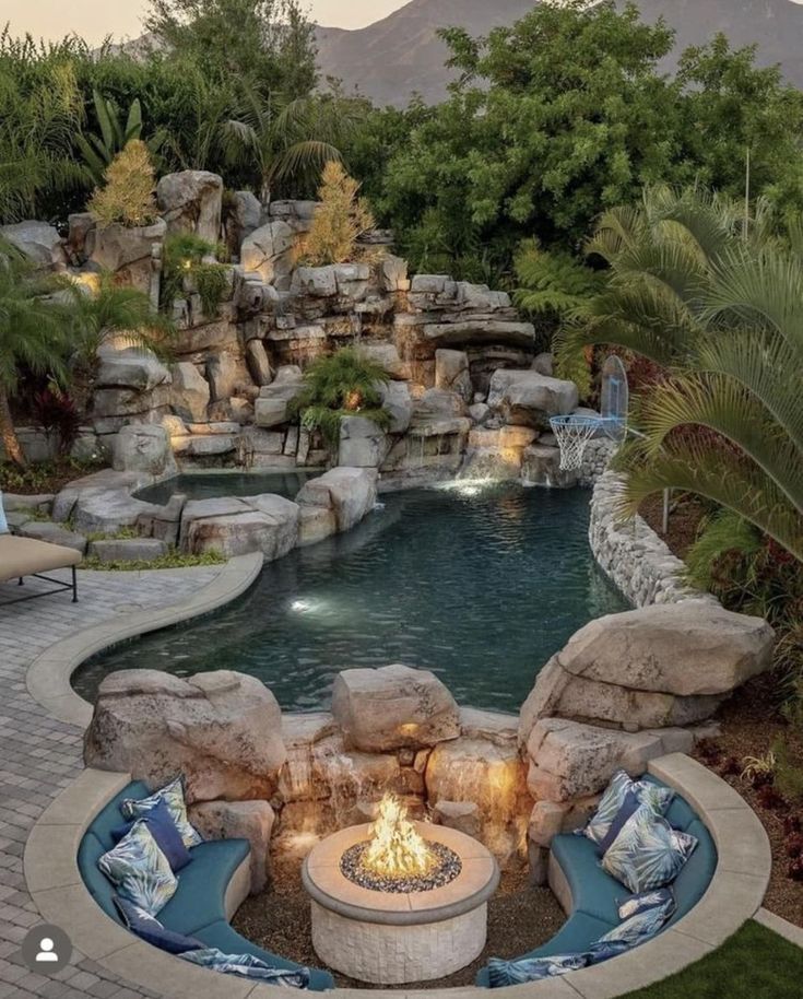 a fire pit in the middle of a pool surrounded by rocks