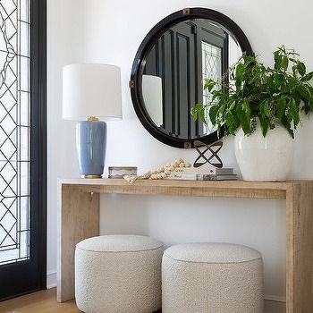 a table with two stools and a mirror on the wall in front of it