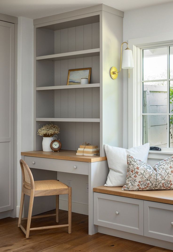 a room with a desk, chair and window seat in front of the windowsill