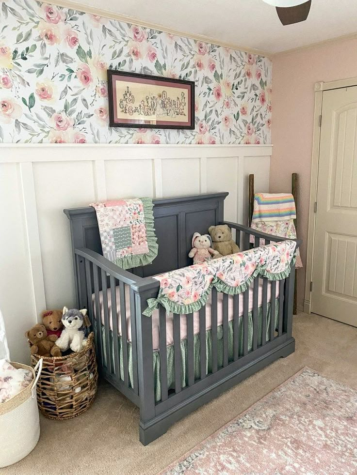 a baby's room with floral wallpaper and teddy bears in the crib