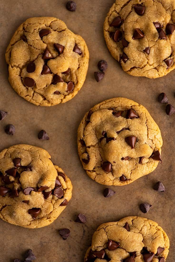 four chocolate chip cookies on a baking sheet