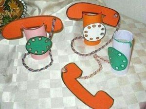 an orange and green phone sitting on top of a table next to two cups with chains around it