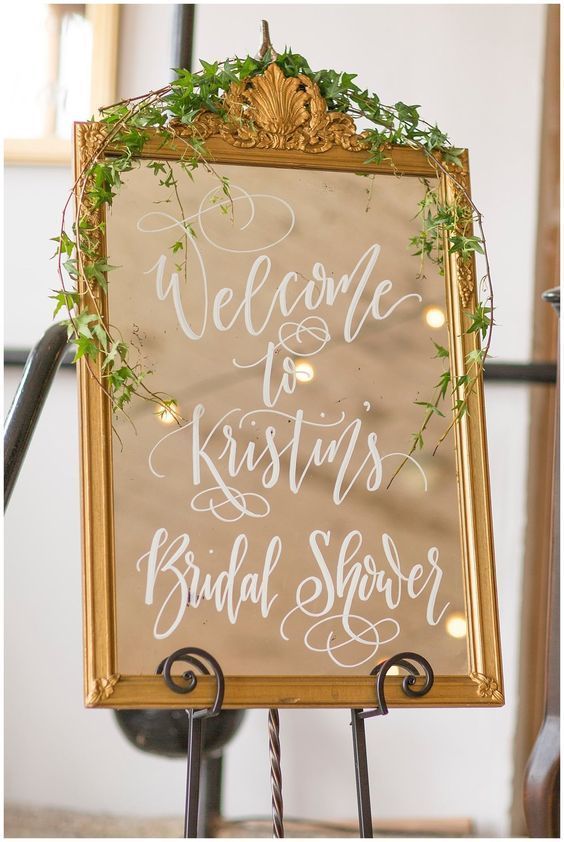 a welcome sign for the bride and groom to arrive at their wedding ceremony with greenery on top