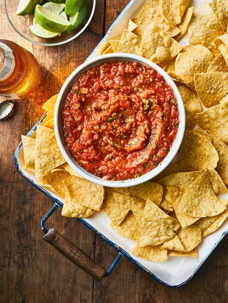 a bowl of salsa with tortilla chips on the side