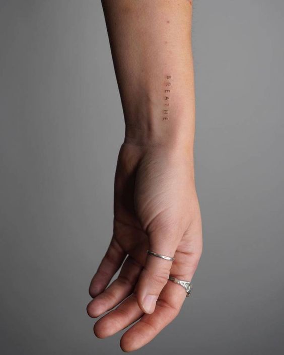 a person's hand with the word love tattooed on their left arm and wrist