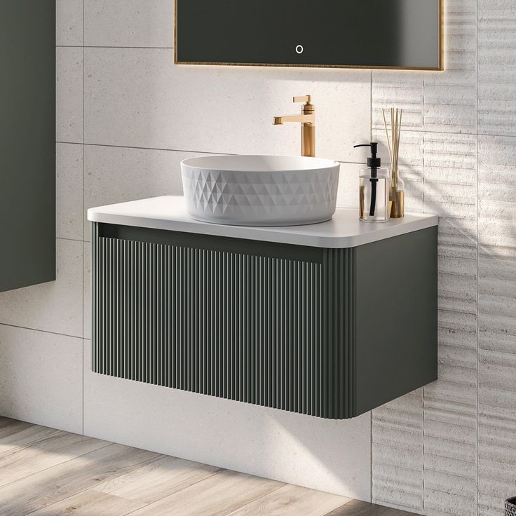 a white sink sitting under a mirror next to a faucet mounted on a wall