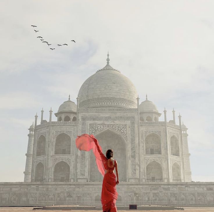 a woman in a red dress is standing near the tajwa