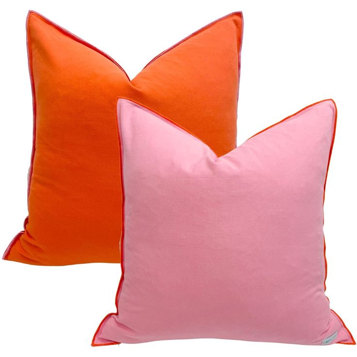 two orange and pink pillows sitting next to each other