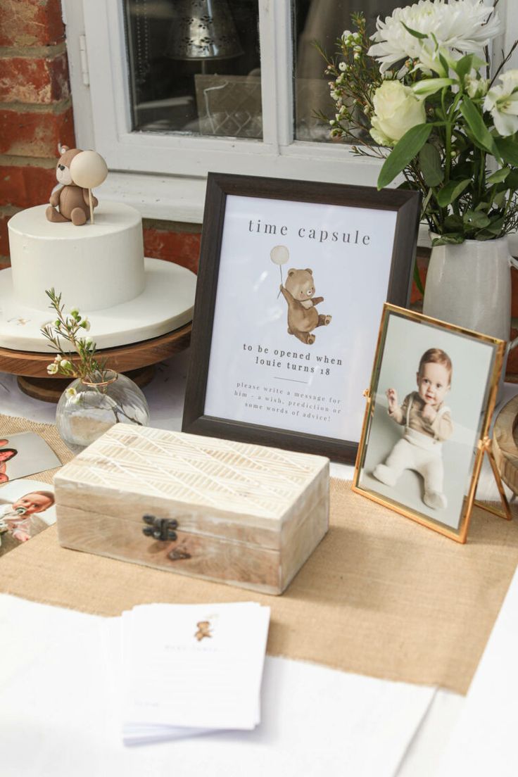 a table topped with pictures and cake next to a window