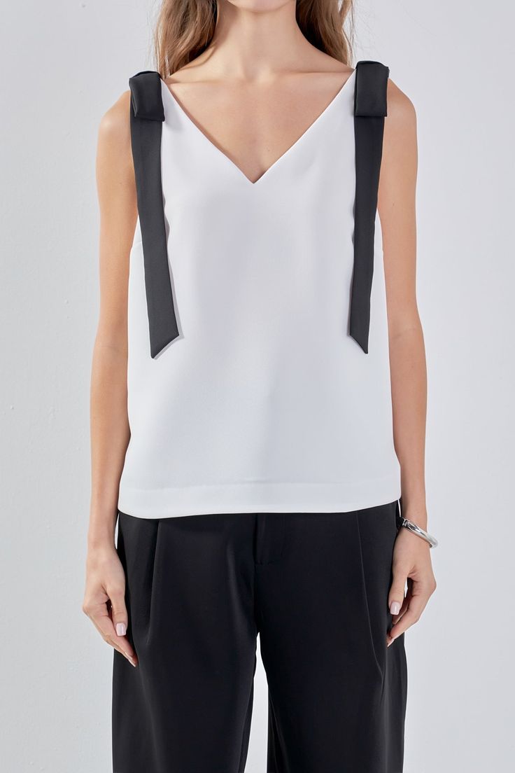 Introducing our charming Bow Detailed Top as the must-have addition to your wardrobe! This versatile top features a flattering V neckline and sleeveless design perfect for layering or wearing on its own. The self-tie bow details at the shoulders add a touch of elegance and femininity making this top a true standout. Crafted with a comfortable pull over design it's easy to wear and style for any occasion. Elevate your look with this trendy top that is bound to turn heads. Shop now and stay ahead Elegant V-neck Top With Bow, Summer Evening Top With Bow Detail, Summer Evening Top With Bow, Casual Sleeveless Top With Bow Tie Back, Sleeveless Top With Bow For Day Out, Chic Fitted Tank Top With Bow, Chic Evening Tops With Bow Tie Back, Spring V-neck Top With Bow, Spring V-neck Top With Bow Detail