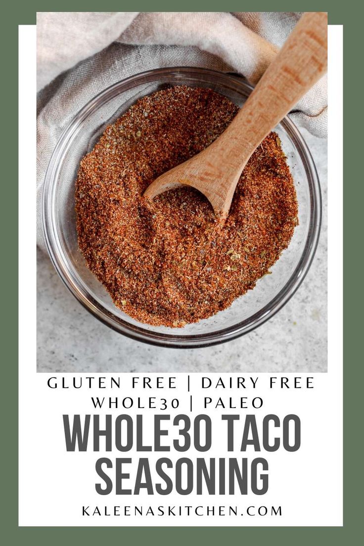 whole 30 taco seasoning in a glass bowl with a wooden spoon on top