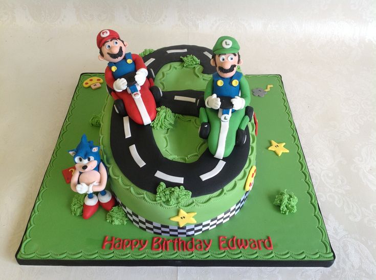 a green birthday cake with mario and luigi on the top is decorated in fondant