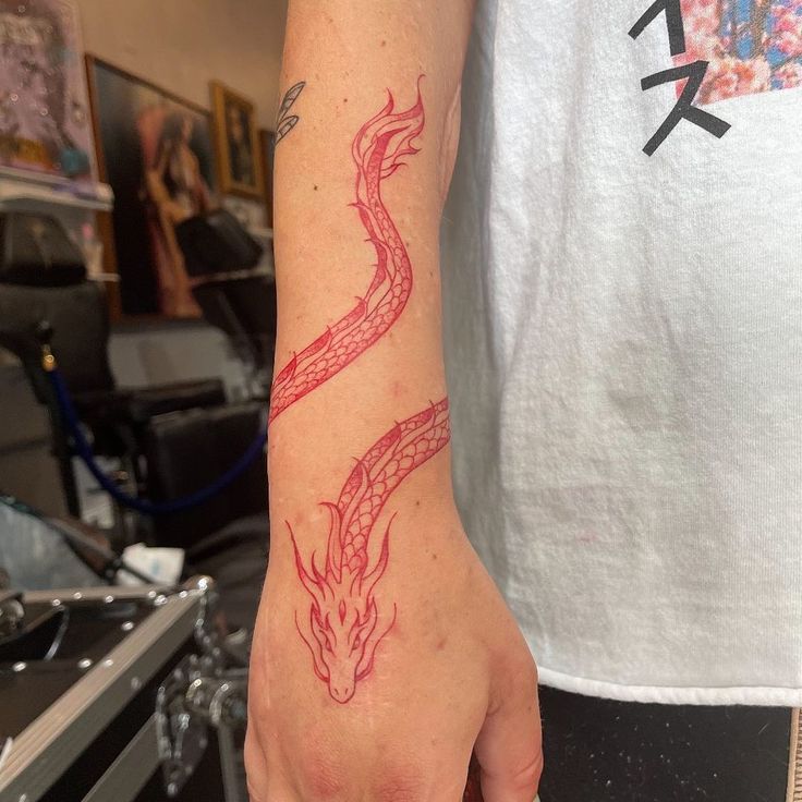 a person with a red dragon tattoo on their arm