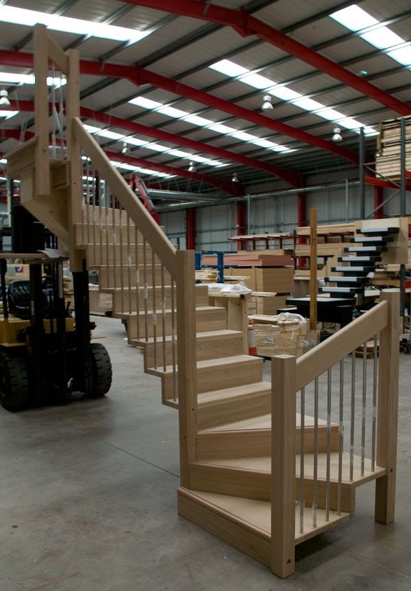 a set of stairs in a warehouse with boxes on the floor and fork lift behind it