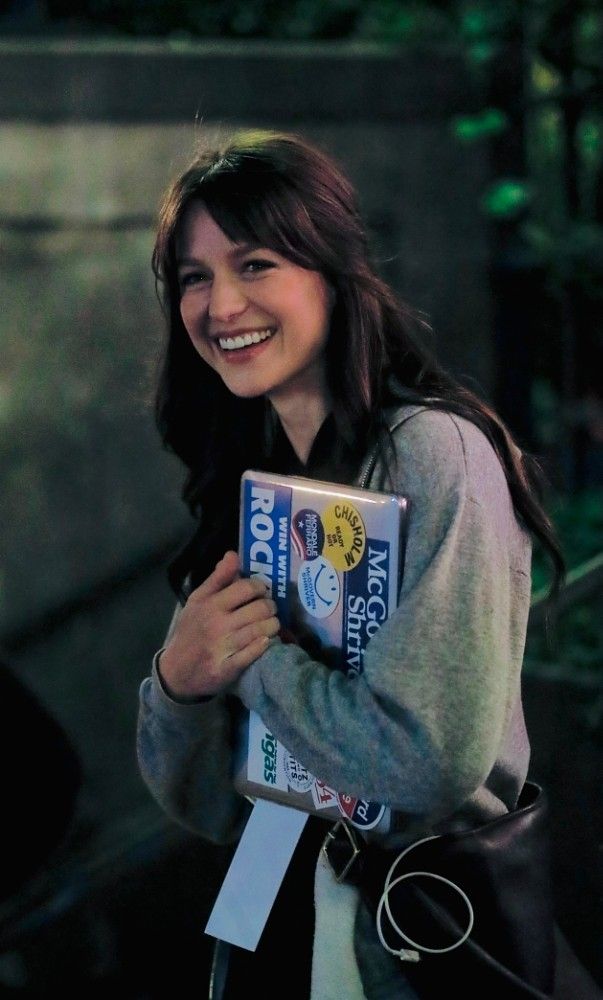 a woman is smiling while holding a book