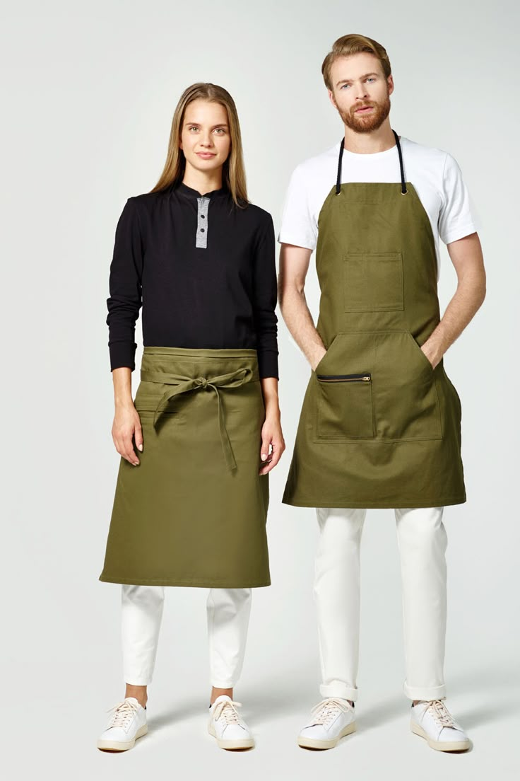 two people standing next to each other wearing aprons