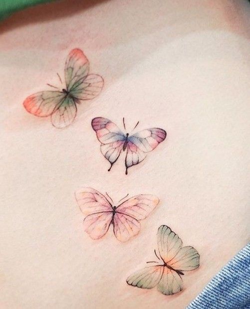 three butterfly tattoos on the side of a woman's stomach