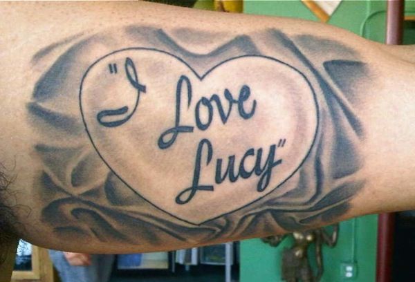 a man's arm with a tattoo that says i love lucy on the heart