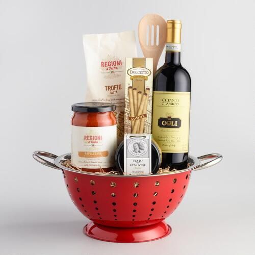 a red colander filled with wine, cheese and condiments on a white background